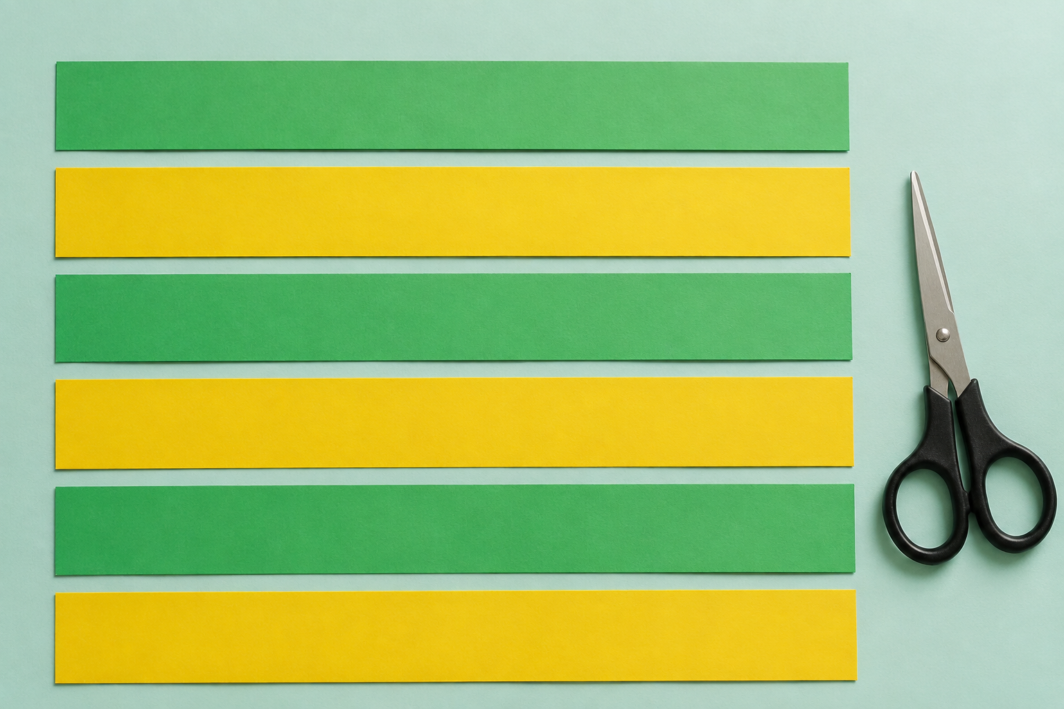 Zes losse papierstroken, drie groene en drie gele, met een schaar ernaast.